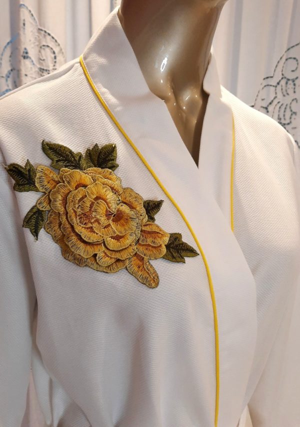 Manequim veste robe longo branco com vivo e flor amarelo